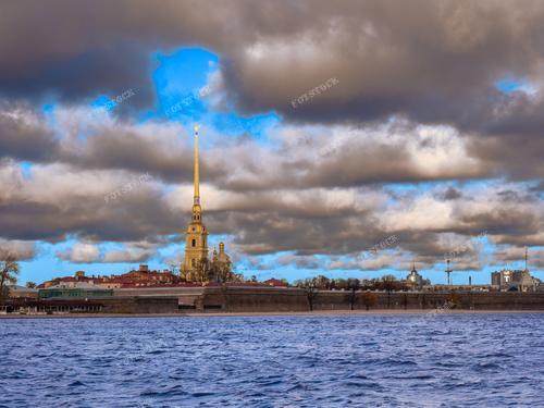Фотография осеннего Петербурга приглашает вас в удивительное путешествие вокруг Петропавловской крепости, где облака лениво плывут над историческими местами города. На заднем плане простирается река Нева, создавая меланхоличное и в то же время величественное сочетание осенней природы и архитектурного великолепия.

Снимок запечатлевает осеннюю атмосферу в Петербурге, где спираль Петропавловской крепости возвышается над рекой, а облака легко скользят по небесам. Эта фотография — чудесный способ привнести в ваш дом кусочек уюта и загадочной красоты российской столицы.

Архитектурные детали Петропавловской крепости, окруженной золотой осенней природой, делают этот снимок уникальным. Приобретите это фото, чтобы погрузиться в атмосферу осеннего Петербурга и насладиться его красотой в любое время года.